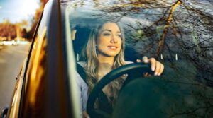 Jovem condutor ao volante de um carro, representando a importância do seguro automóvel para todos os motoristas